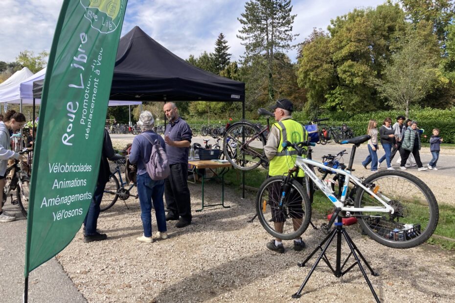 Des personnes discutent autour d'un stand de l'association Roue Libre, à l'occasion de la fête du vélo au lac d'Aiguebellette.