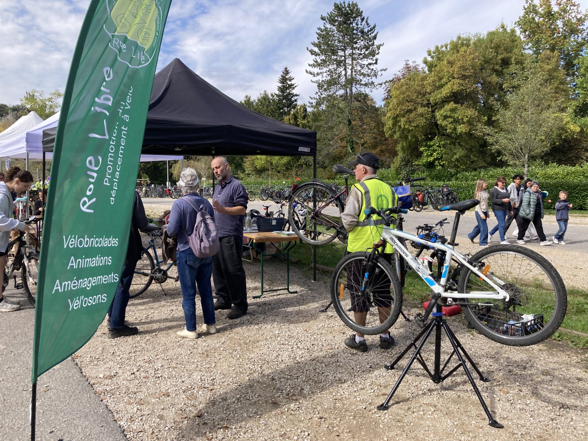 Des personnes discutent autour d'un stand de l'association Roue Libre, à l'occasion de la fête du vélo au lac d'Aiguebellette.